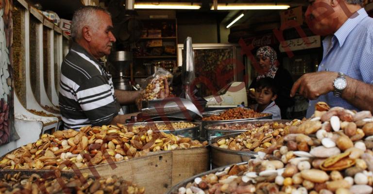 مواطن يشتري المكسرات من محل بوسط البلد- عدسة منى عمري 