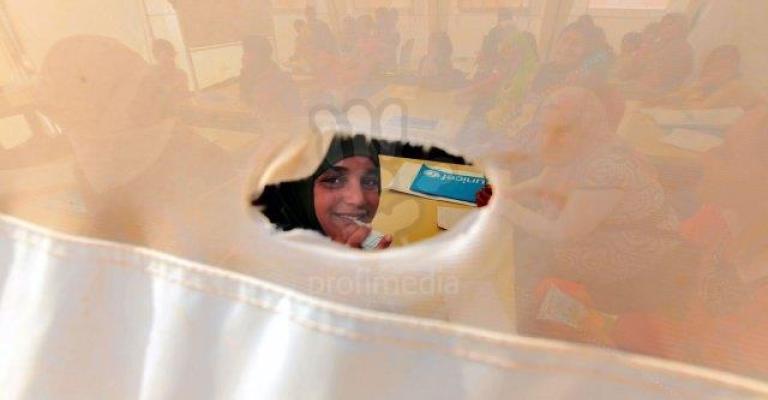 طفلة في الزعتري تنظر من ثقب الخيمة