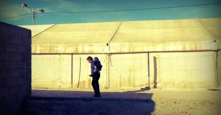 أب يلاعب طفلته في الزعتري