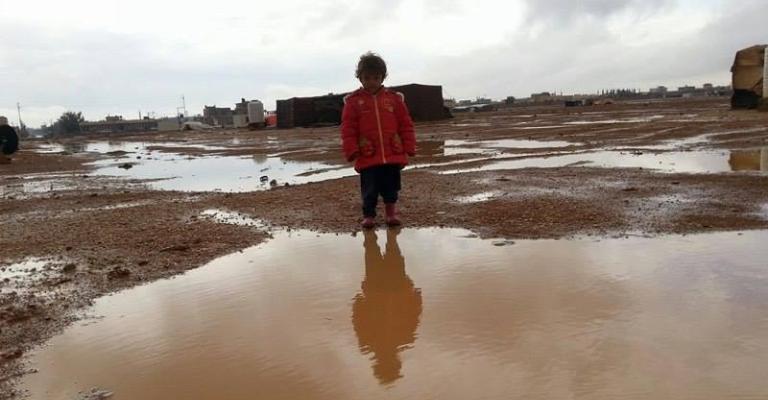 طفل سوري يتوسط برك من مياه الأمطار في مخيم صغير داخل مخيم الزعتري/تصوير محمد الشريف