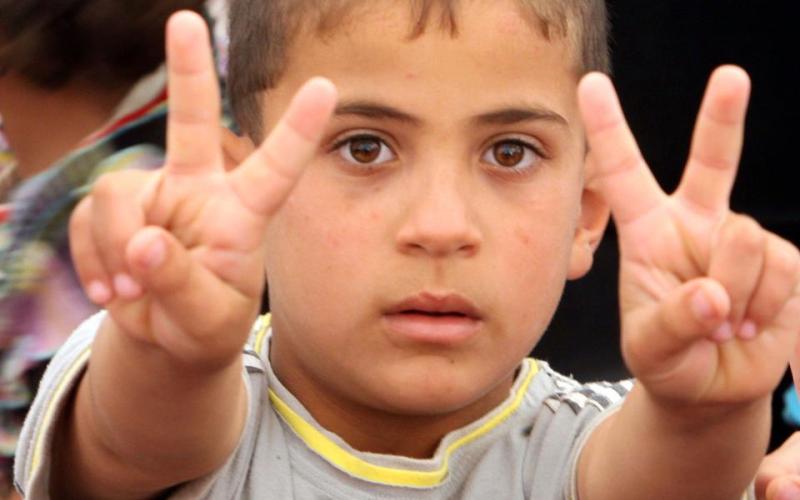طفل سوري يرفع شارة النصر- عدسة حمزة مزرعاوي/ فيسبوك 