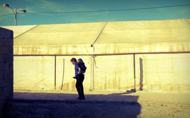 أب يلاعب طفلته في الزعتري