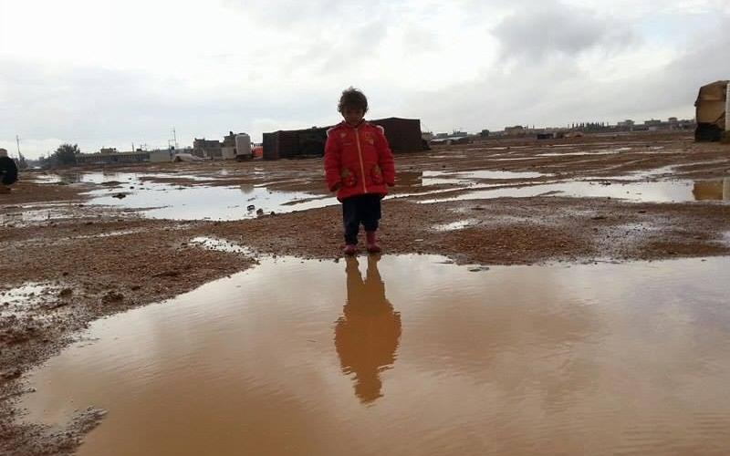 طفل سوري يتوسط برك من مياه الأمطار في مخيم صغير داخل مخيم الزعتري/تصوير محمد الشريف